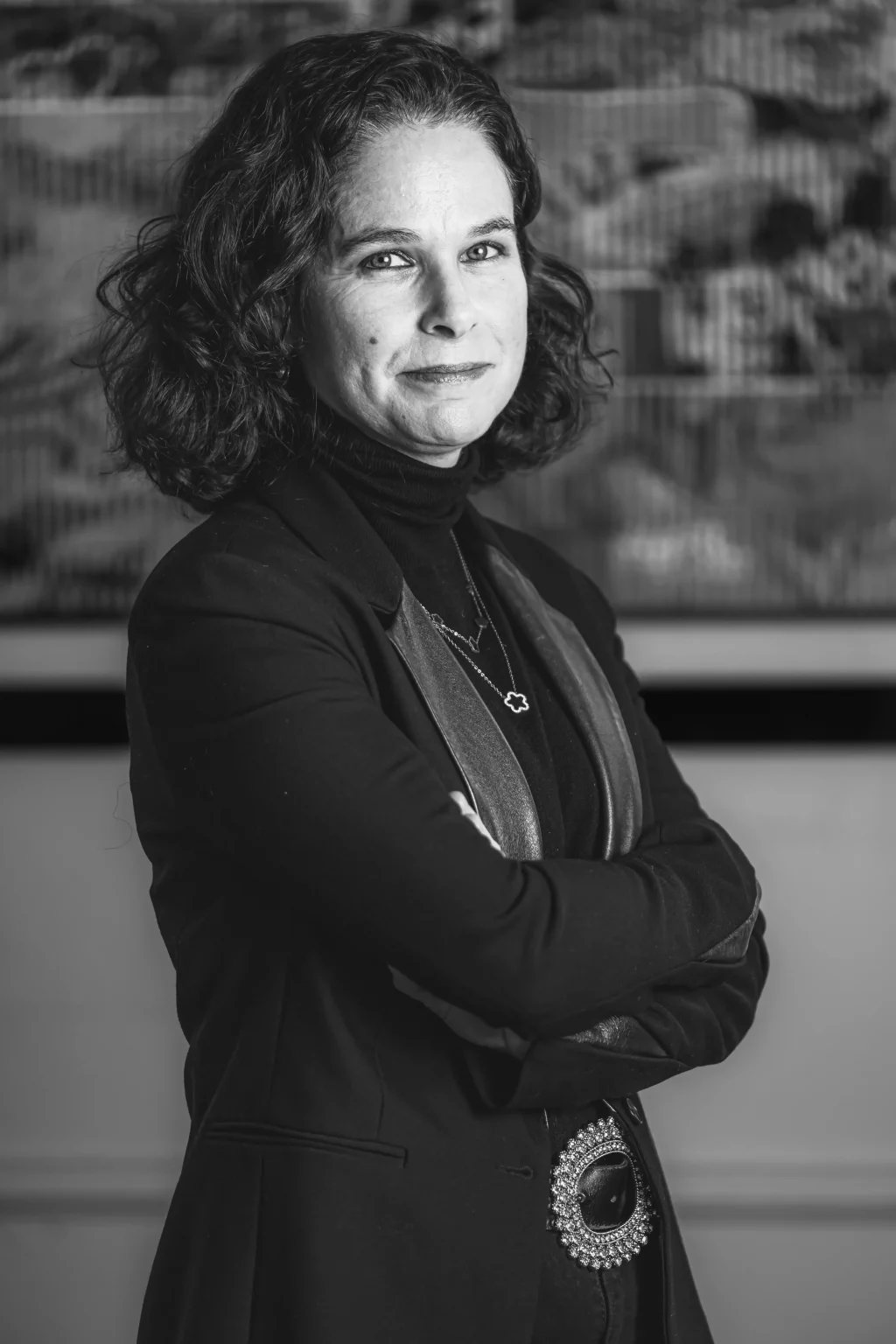 Portrait en noir et blanc d’une avocate du cabinet BERGHEIMER, bras croisés, exprimant assurance et professionnalisme