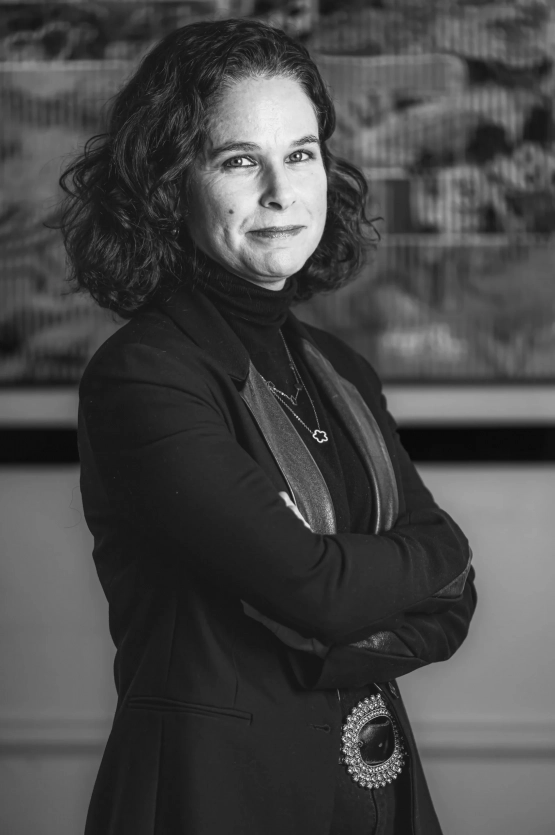 Portrait en noir et blanc d’une avocate du cabinet BERGHEIMER, bras croisés, exprimant assurance et professionnalisme